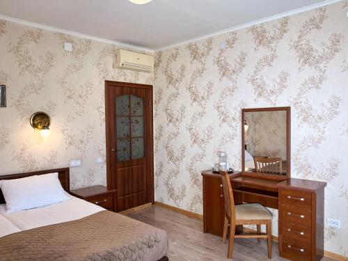 a bedroom with a bed and a desk and a mirror at Hotel Plazma in Lviv