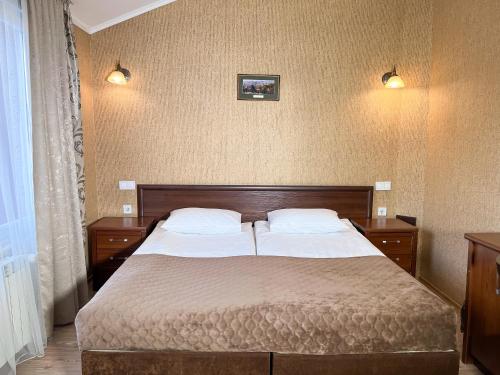 a bedroom with a bed with two white pillows at Hotel Plazma in Lviv