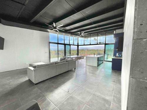 a living room with a couch and tables and windows at Vineyard l Privacy l Terrace l BBQ l Playground FINCA MD in Ensenada