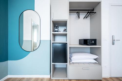 a room with a mirror and a bed and a shelf at - NumberZ - Rooms Apartments and Suites with Wi-Fi and AC in Borgo Isonzo