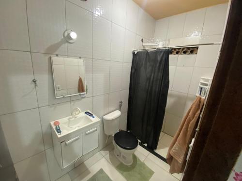 a bathroom with a sink and a toilet and a shower at Casa raízes do bem in São Pedro da Aldeia