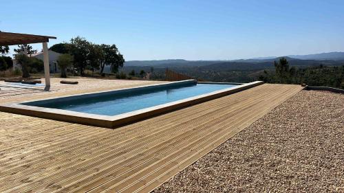 a swimming pool on top of a wooden deck at Vale das Estrelas in São Teotónio