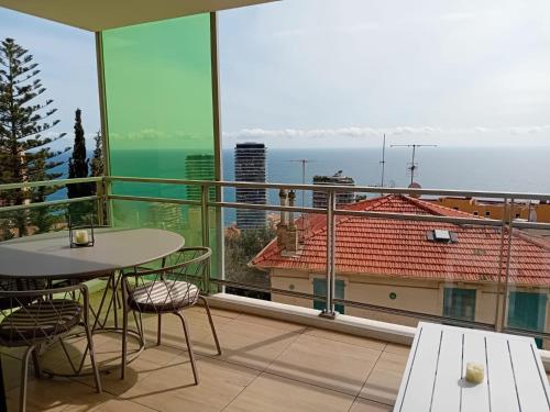 a balcony with a table and chairs and a view of the ocean at Luxury Apartment MonacoView in Beausoleil
