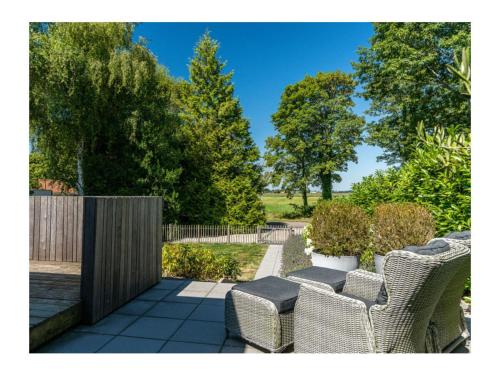 a patio with wicker chairs and a wooden fence at Charming villa with garden in Rijs