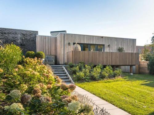 a wooden house with a garden in front of it at Charming villa with garden in Rijs