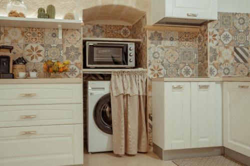 a kitchen with a washing machine and a microwave at Casa Vacanza Il Piccolo Principe in Ginosa