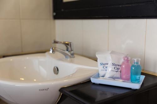 a bathroom sink with soap and detergents on a counter at Star House Patong in Patong Beach
