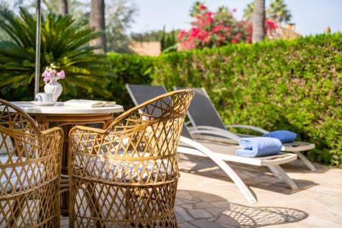a patio with a table and chairs and an umbrella at Hotel Son Molí Country House in Playa de Palma