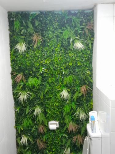 a bathroom with a green wall with plants at Durban Beachfront 10 South Apartments 1404 in Durban