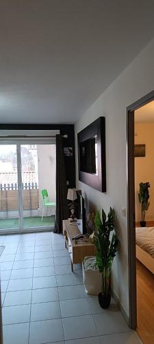 a living room with a bed and a tv on a wall at Le refuge du Bassin - T2 Charme et confort in Lanton