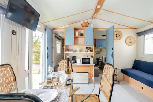 a dining room and living room with a glass table at 1A Casa Azul in Pataias