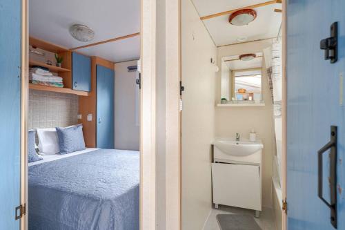a small bedroom with a bed and a sink at 1A Casa Azul in Pataias
