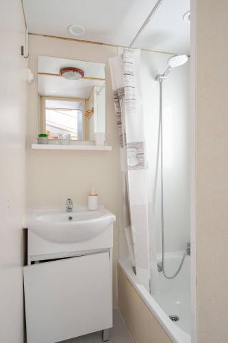 a white bathroom with a sink and a shower at 1A Casa Azul in Pataias