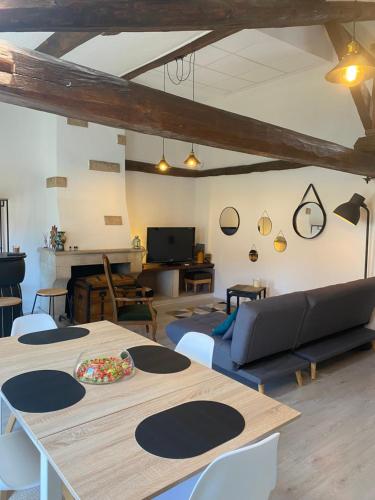 un salon avec une table et des chaises dans l'établissement Le Nid Paisible, à Verdun-sur-Meuse