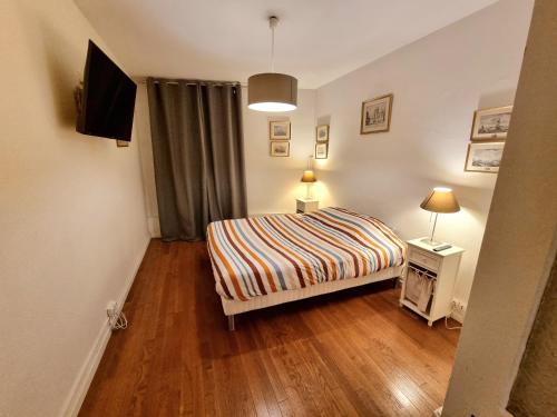 une petite chambre avec un lit et une télévision dans l'établissement Clos des Jardiniers 2, à Villefranche-sur-Saône