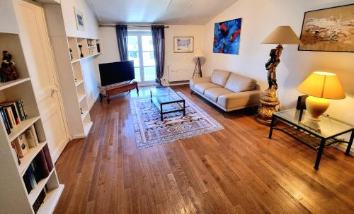 un salon avec un canapé et une télévision dans l'établissement Clos des Jardiniers 2, à Villefranche-sur-Saône