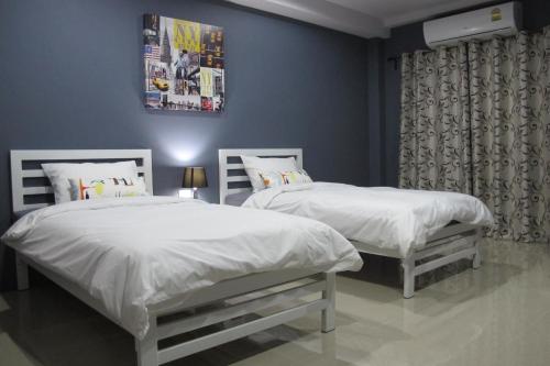 two beds in a bedroom with blue walls at Sweet Dreams in Phetchaburi