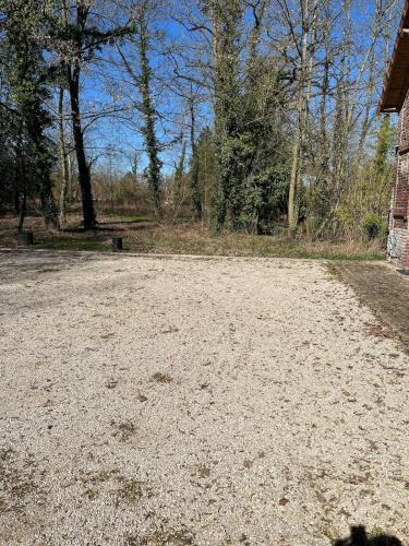 an empty dirt road next to a brick building at Le Paradis 210 m2 en pleine nature in Cambrai