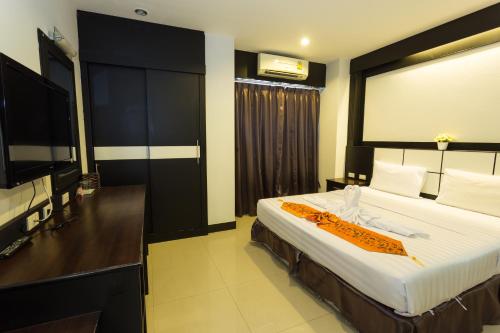 a hotel room with a bed and a flat screen tv at Star House Patong in Patong Beach
