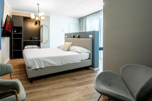 a bedroom with a bed and two chairs at - NumberZ - Rooms Apartments and Suites with Wi-Fi and AC in Borgo Isonzo