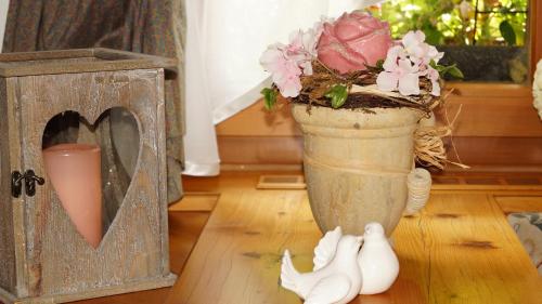 a vase with flowers and a candle on a floor at Hotel Schwarzenbergs Traube in Glottertal