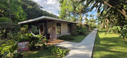a small house with a sidewalk next to a yard at Hotel Catarata Río Celeste in Bijagua