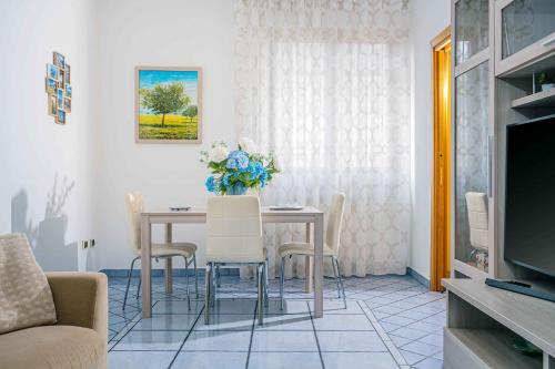 a living room with a table and chairs and a television at I Tre Delfini apartment in center-Sorrento Coast in Vico Equense