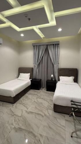 two beds in a room with a coffered ceiling at ازورايت الردف لبيوت العطلات in Taif