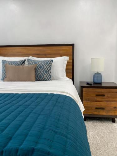 a bedroom with a bed and a nightstand with a blue lamp at The 605 House in De Smet
