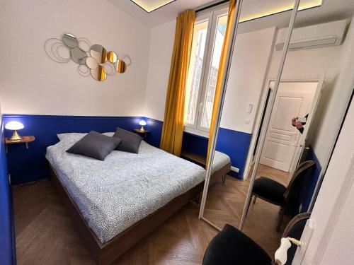 a small bedroom with a bed and a mirror at Casa Mia Moneghetti in Beausoleil