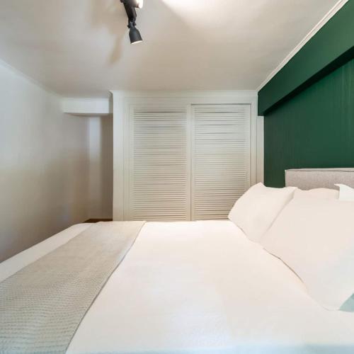 a bedroom with a white bed and a green wall at 4bd Apartment With Outdoor Jacuzzi Garden in Athens
