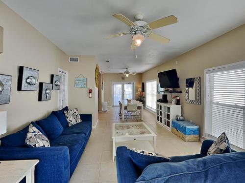 a living room with blue couches and a ceiling fan at La Favorita in Navarre