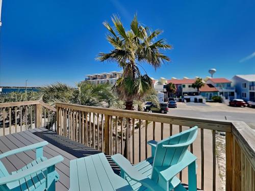 two blue chairs and a palm tree on a deck at La Favorita in Navarre