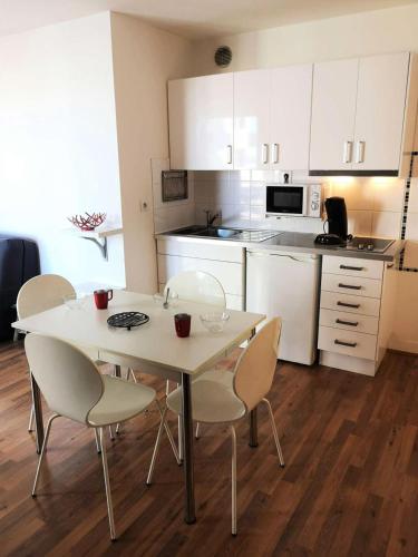 une cuisine avec une table et des chaises dans une cuisine dans l'établissement Résidence Port Arcachon - Arcachon - Studio dans le quartier de l'Aiguillon MAE-8354, à Arcachon