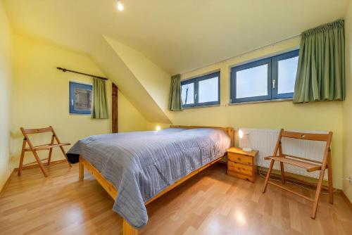 - une chambre avec un lit et deux chaises dans l'établissement Kinderfreundliche Ferienanlage In Idyllischer Lage, à Neuenkirchen