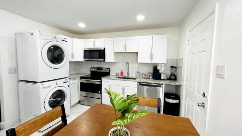 a kitchen with white cabinets and a wooden table with a plant at Close to the beach #1 Lovely 2 bedrooms condo in Myrtle Beach