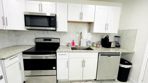 a kitchen with white cabinets and a stove and a microwave at Close to the beach #1 Lovely 2 bedrooms condo in Myrtle Beach