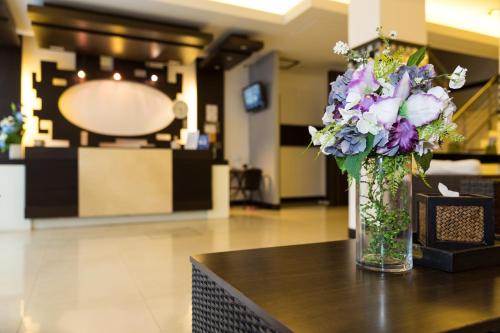 a vase of flowers sitting on top of a table at Star House Patong in Patong Beach