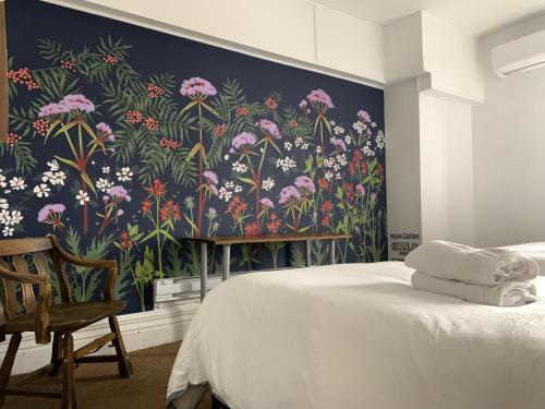 a bedroom with a floral wall mural next to a bed at Pensione Popolo in Montréal