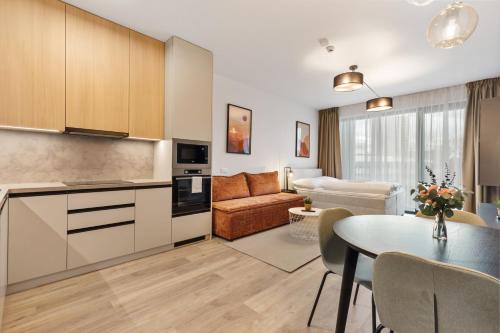 a kitchen and living room with a table and a couch at LAM Terracotta - AC - Balcony in Bratislava
