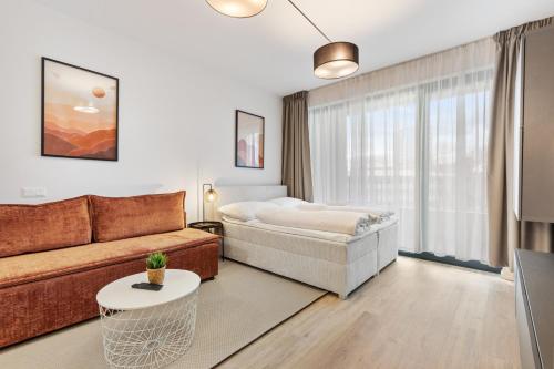 a living room with a couch and a bed at LAM Terracotta - AC - Balcony in Bratislava