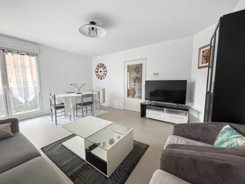 a living room with a couch and a table at Spacieux & lumineux avec balcon in Beauvais