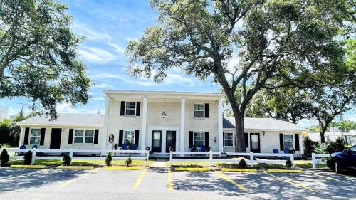a white building with a car parked in a parking lot at Close to the beach #4 Cozy condo in Myrtle Beach