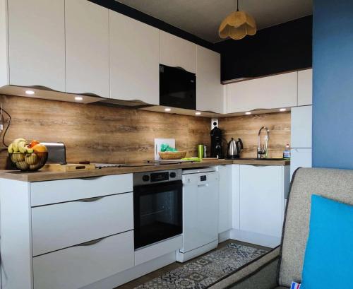 une cuisine avec des armoires blanches et un comptoir dans l'établissement Résidence Antares - Charmant T2 entièrement rénové avec vue imprenable sur le bassin MAE-9344, à Arcachon