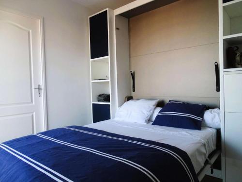une chambre avec un lit avec des draps bleus et blancs dans l'établissement Résidence Antares - Charmant T2 entièrement rénové avec vue imprenable sur le bassin MAE-9344, à Arcachon