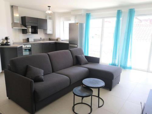 un salon avec un canapé et une cuisine dans l'établissement Résidence Dignan - Arcachon - T3 centre-ville MAE-9464, à Arcachon