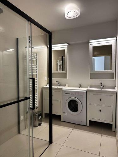 La salle de bains est pourvue d'un lave-linge et de deux lavabos. dans l'établissement Résidence Dignan - Arcachon - T3 centre-ville MAE-9464, à Arcachon