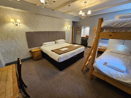 a bedroom with two beds and a bunk bed at The Sun Inn in Troutbeck Bridge