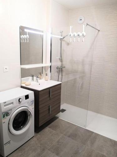 une salle de bain avec une machine à laver et un lave-linge dans l'établissement Résidence Villa Marine - Appartement neuf T3 au centre-ville d'Arcachon MAE-9484, à Arcachon