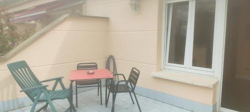 un tavolo e delle sedie su un balcone con una finestra di Habitación triple con bañera y terraza HOTEL SUITE MIOÑO a Castro-Urdiales